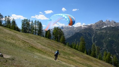 Neustift im Stubaital, Austria – May 28, 2017. Paraglider taking off and flying over Stubaital valley in Tirol, Austria.