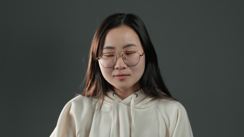 Portrait of young asian woman doing facepalm gesture, like no, I forgot! Unhappy korean woman with long hair feeling sorrow, regret, drama, failure. She isolated on grey wall