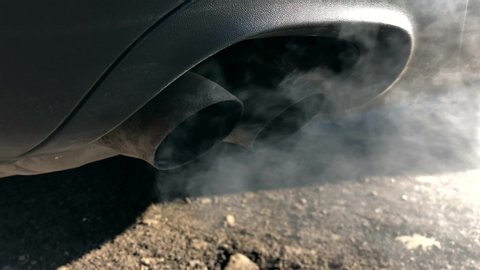 A diesel car pollutes the air with smoke from the exhaust pipes