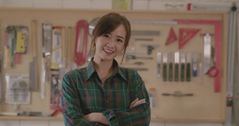 Worker young asian woman carpenter crossed arm smiling building design wooden working in workshop office studio, Personal business concept, Slow motion .