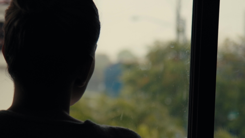 Young Lonely Depressed Woman Looking Out Through The Window of Her House During The Coronavirus Pandemic Quarantine Lockdown and Rainy Day. Stay at Home Royalty-Free Stock Footage #1051103191