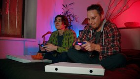Two young men friends playing game with gamepads and one of them loses