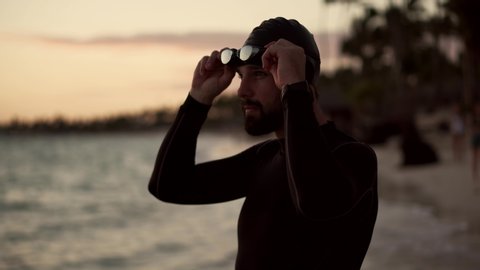Triathlete Preparing To Triathlon Swim Competition.Swimmer Workout In Ocean Water.Professional Triathlete Preparing To Swimming.Professional Swimmer Wearing Cup And Goggles.Sport Competition Concept.