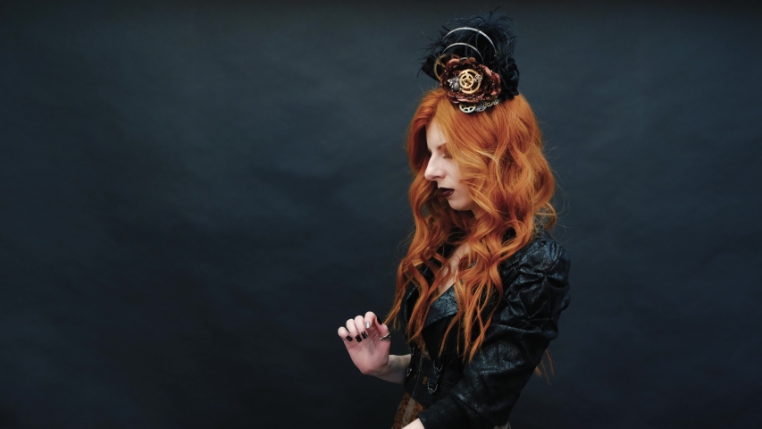 gothic girl wears rings on her fingers in front of the camera