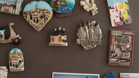 Putting travel magnets from vacations Venice (Italiano Venezia) on a fridge, travel concept
