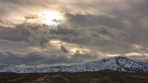 Sun Rays at Sunset with Rolling Snow Clouds Behind a Snow Covered Mt. Charleston Time Lapse, Timelapse, Time-Lapse, 4K