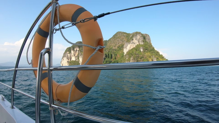 Red rubber rings on a boat in the sea  Sky blue  With mountains in the background in Thailand