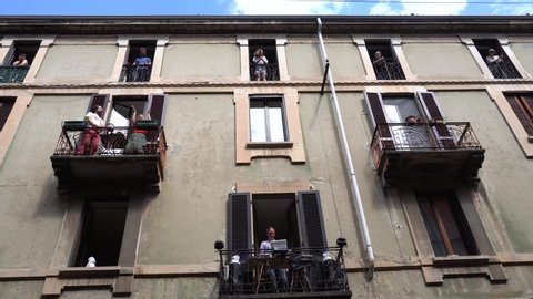 Italy, Milan April 25, 2020  day of the Resistance during covid 19 Coronavirus quarantine at home - Italian flash mob on the windows , balconies of the house - people dancing and applaud 