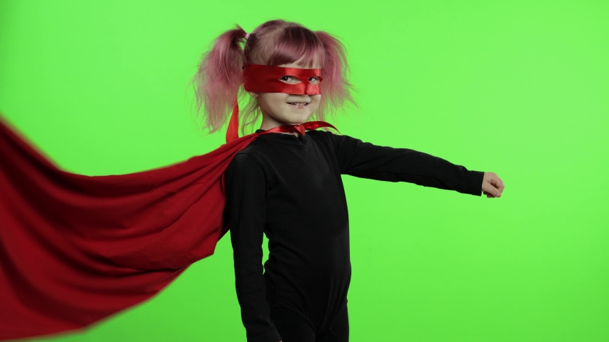 Cute baby girl play superhero. Funny child in homemade costume of super hero with red cape and mask. National superhero day concept. Portrait close up. Makes expressions and look at camera. Chroma key Royalty-Free Stock Footage #1051149997