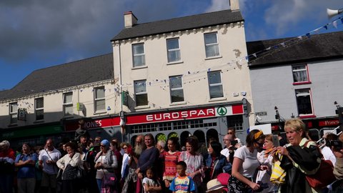 KILLORGLIN, COUNTY KERRY, IRELAND - AUGUST, 2019: Local people and tourists celebrating Puck Fair. Irish pipe band performing outdoors in Killorglin town square.
