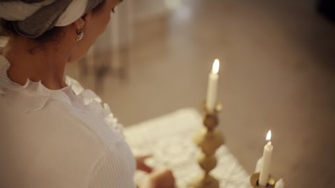 ISRAEL, TEL AVIV JULY 12, 2019 Sabbath Jewish Holiday A woman turns on Shabbath candle