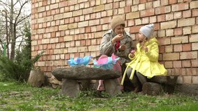 Mother's Day during quarantine. Grandmother and little girl eating cake outdoor.