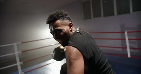 African american sportsman sparring on a boxing ring, punching his opponent at camera - sports, active way of life concept 4k footage