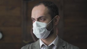 Confident businessman is standing in the pollution masked working in the office during the quarantine period negotiating a video conference with clients. Prores 422.