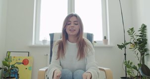 Smiling young woman working at home. Girl speaking looking at tablet talking making videochat or conference call, Happy female greeting waving hand, 4k webcam view slow motion