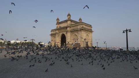 Mumbai, India: April 16, 2020: Deserted roads and very minimum traffic and crowd at Gateway of India in Mumbai due to Covid 19 pandemic lock down. Very few people moving around with masks.
