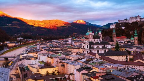 Salzburg, Austria. Aerial view of popular destination city in Austria - Salzburg at sunset. Castle and Cathedral with mountain at the background, panning video