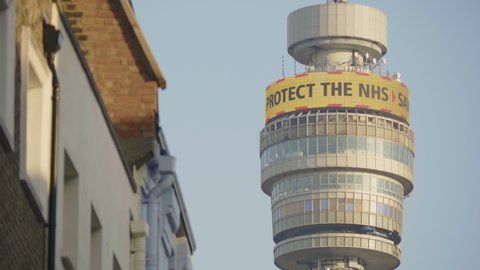 BT Tower, London / UK - April 23 2020: Tight Shot of BT Tower showing NHS Stay at Home advice on Digital Out of Home display. Coronavirus London Lockdown.