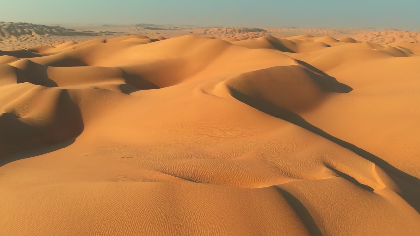 Rub' al Khali (Empty Quarter), Arabian Peninsula. Flying over sand dunes in desert. Camera moving rightwards. Aerial shot, UHD Royalty-Free Stock Footage #1051189990