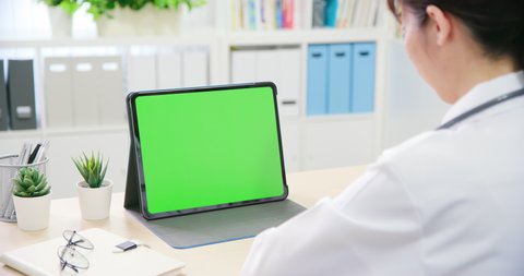 telemedicine concept - asian female doctor use green screen tablet pc to see the patient and give advice