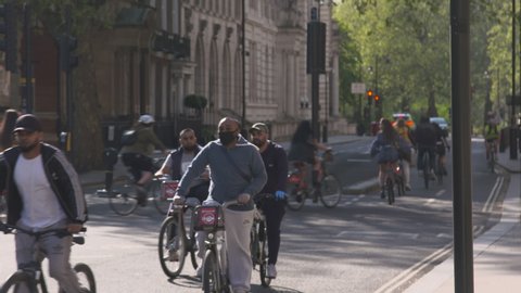 London, UK - April 21 2020: Coronavirus Outbreak lockdown - Groups of people cycling in Parliament Square
