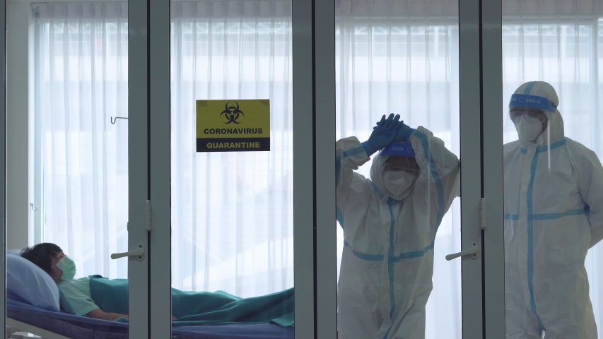 Doctor and nurse in personal protective equipment or ppe feel depressed, burnout, and sad after overwhelming with hard work in treating many patient with covid-19 or coronavirus in hospital | Shutterstock HD Video #1051201159