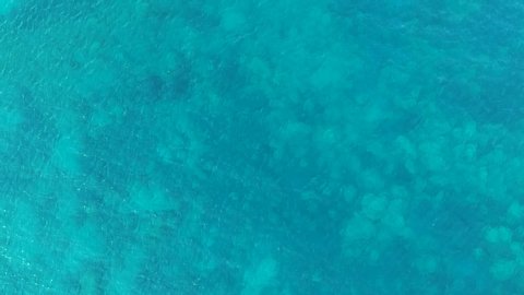 Turquoise blue water with coral reefs below on the island of Zakynthos Greece, Aerial drone lift view from above