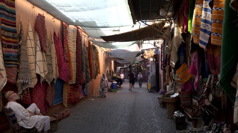 MARRAKESH, MOROCCO- JUNE, 9, 2019: a gimbal stabilized clip walking past a carpet shop in a marrakesh lane way of morroco