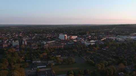 Aerial view panning around a generic town in Surrey, England during sunset in Covid Lockdown