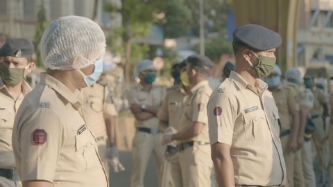 On duty Policemen/ police force/ constables in uniform standing on the road wearing proactive face mask during city lockdown amid coronavirus/ covid19 epidemic/ pandemic in Mumbai, India (April 2020)