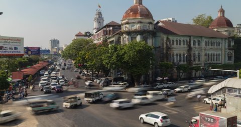 Yangon, Myanmar - December 19, 2019: Timelapse of the rush hour traffic jams in Yangon, in front of the Yangon Divisional Court building and the second-hand night market area, over Strand Road.