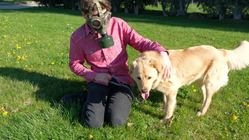 boy wearing old style virus mask   with his dog playing at garden
