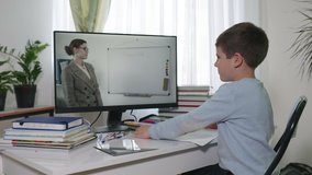 online education, male student at home school watching video broadcast using modern technologies where teacher explains lesson on video communication, quarantine