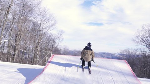 Young male skier doing HUGE FLIP off big terrain park jump stomping landing in Vermont on sunny day - Action/Adrenaline