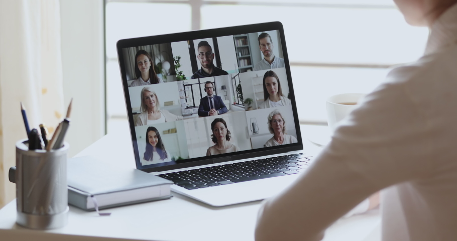 Over shoulder view of business woman remote worker, distance student video conferencing boss and colleagues by group video call using web cam on laptop screen. Virtual team home office chat meeting. Royalty-Free Stock Footage #1051277143
