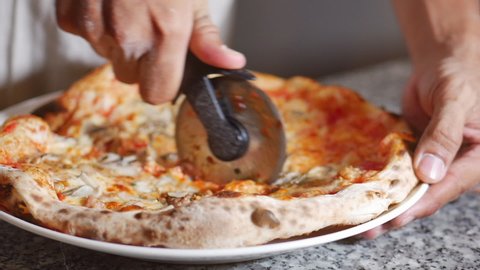 Freshly Pizza of Slicing a Pepperoni Pizza into Multiple Slices With a pizza Cutter. Knife pizza slicing