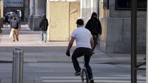 Chicago,IL/USA-April 18th 2020: man biking in the empty streets in the downtown Chicago area during the Covid-19 virus pandemic. the city is closed due to quarantine and business have stopped.