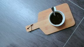 Slow motion , Top view of person hand stirring black coffee with spoon on wooden board with copy space with noise and grain in video