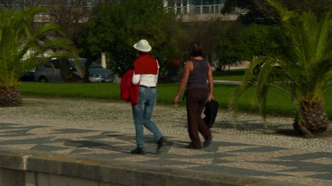 Panning shot of women walking on footpath in park - Figueira da Foz, Portugal