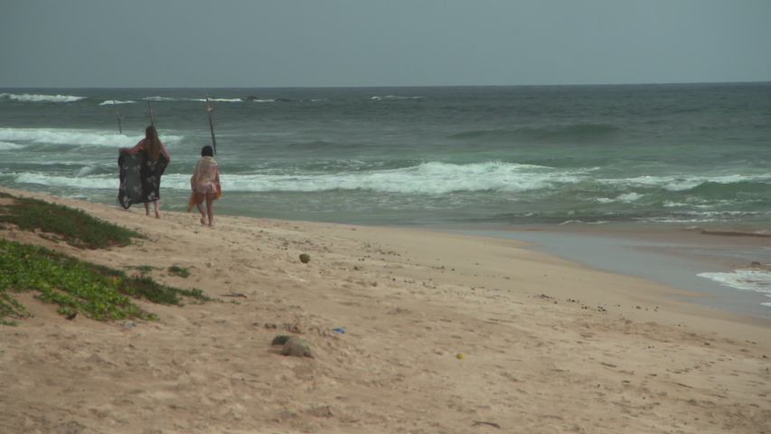 Young women in bikini enjoying at beach against sky - Arugam Bay, Sri Lanka