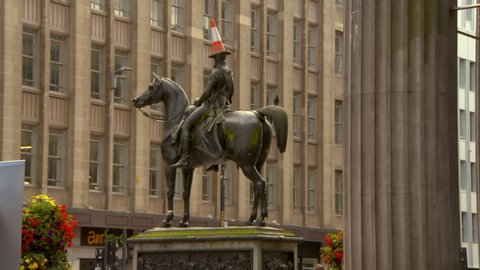 Lockdown shot of iconic equestrian statue against building in city - Glasgow, Scotland
