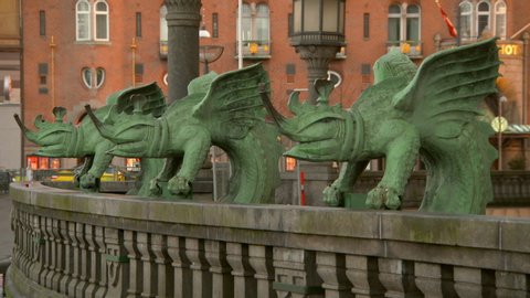 Lockdown shot of green animal statues on railing against building in city - Copenhagen, Denmark