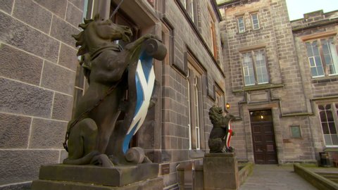 Lockdown shot of animal statues with flags against college building in city - Aberdeen, Scotland