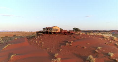 Aerial shot of lodge in resort on hill at desert against sky, drone panning over structure - Namib Desert, Namibia