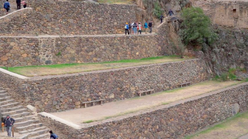 Slow motion shot of tourists exploring at Machu Picchu, people walking at old ruins - Cusco, Peru