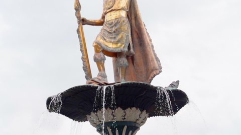 Tilt up shot of metallic statue on fountain against sky, sculpture in city - Cusco, Peru