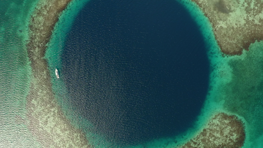 Aerial top view of yacht in marine sinkhole on sunny day, scenic view of seascape - Great Blue Hole, Belize Royalty-Free Stock Footage #1051314397