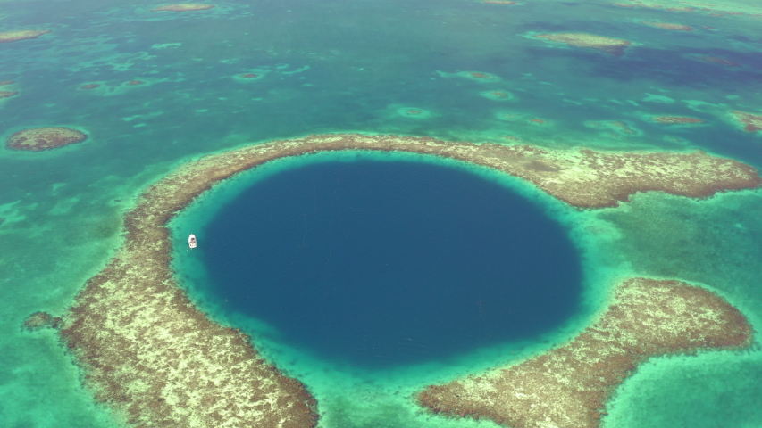 Aerial: Yacht in marine sinkhole on sunny day, scenic view of seascape - Great Blue Hole, Belize Royalty-Free Stock Footage #1051315039