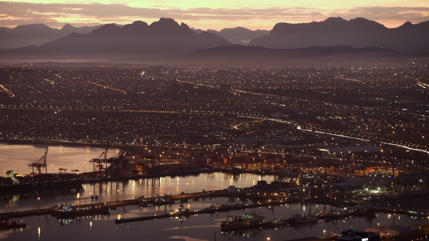 Lockdown shot of the port of a big city among amazing mountains at dusk - Cape Town, South Africa