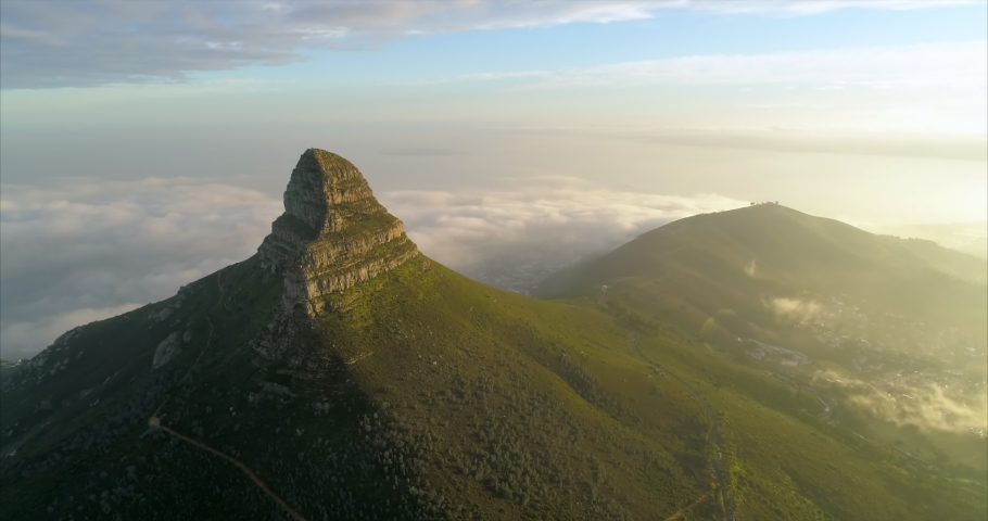 Aerial shot of a beautiful mountain peak over a scenic town, drone turning from left to right - Cape Town, South Africa